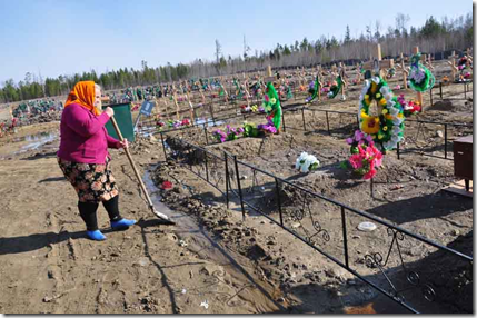 Родственники пытаются самостоятельно отвести воду от могил на Покровском кладбище Кодинска. Фото: Екатерина Первухина
